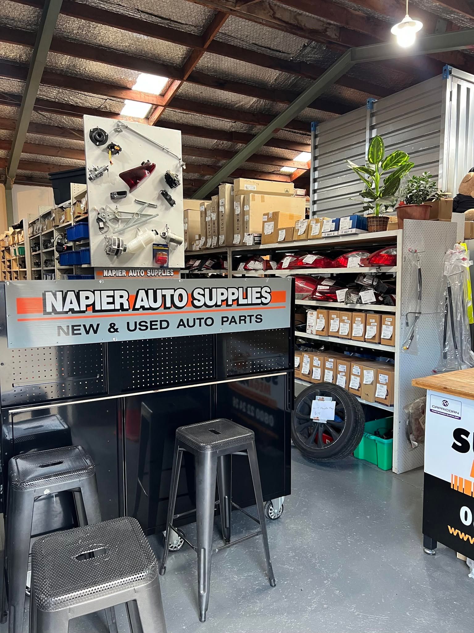 Naper Auto Sales booth with stools, tires, and tools in an indoor garage setting