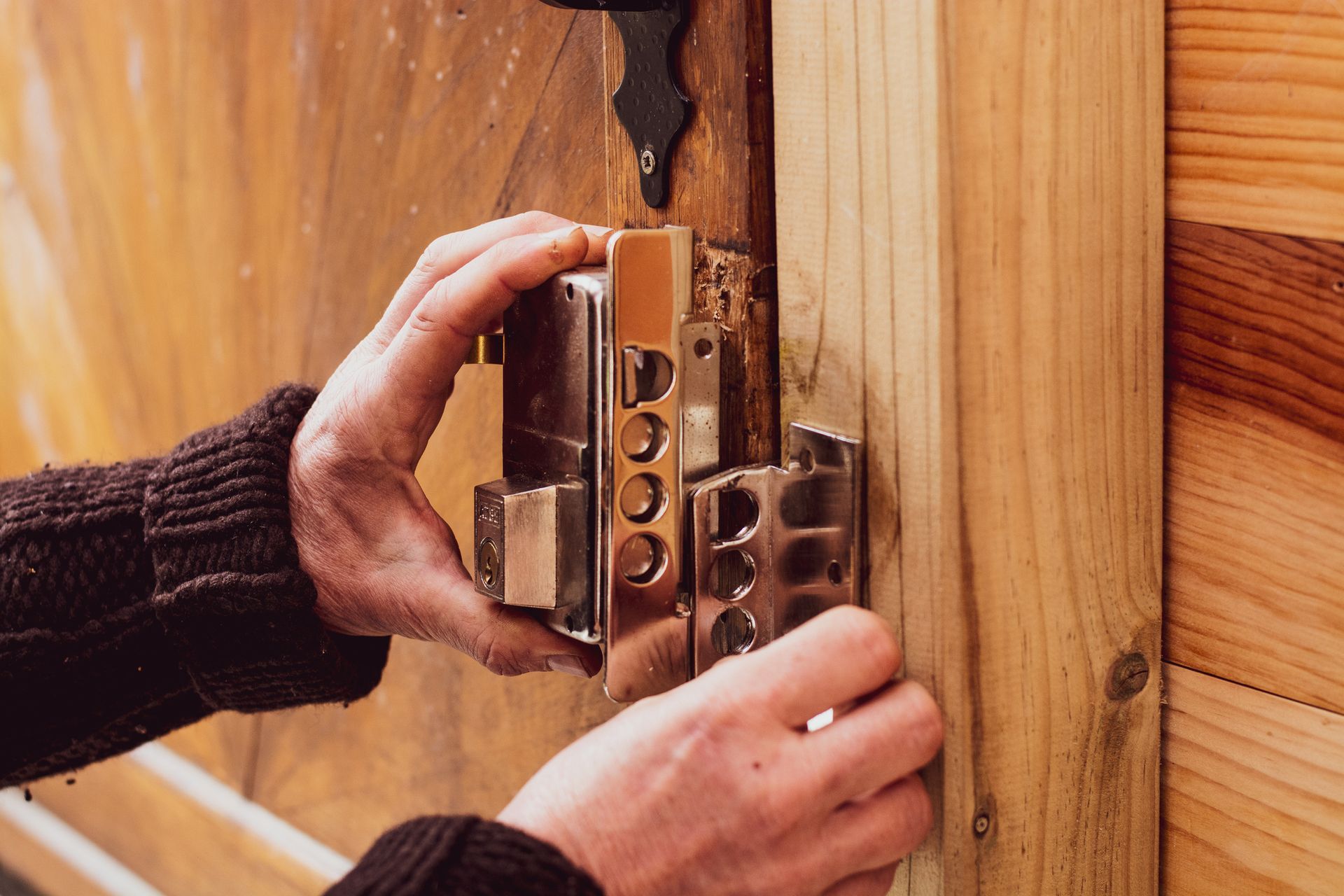 Man Fixing A Lock On A Wooden Door — Suffolk County, NY — Competition Locksmith