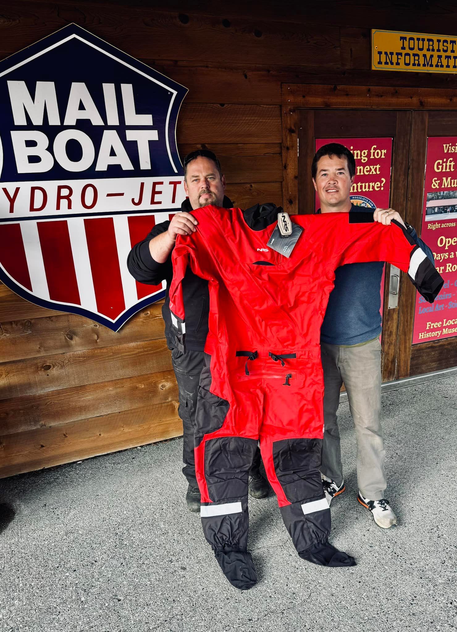 two people holding up a red suit