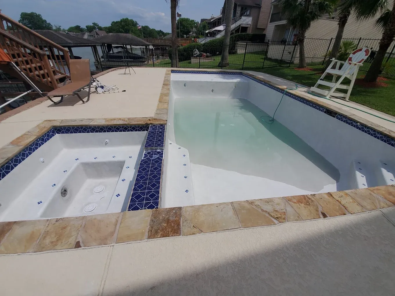 There is a large swimming pool in the backyard of a house.