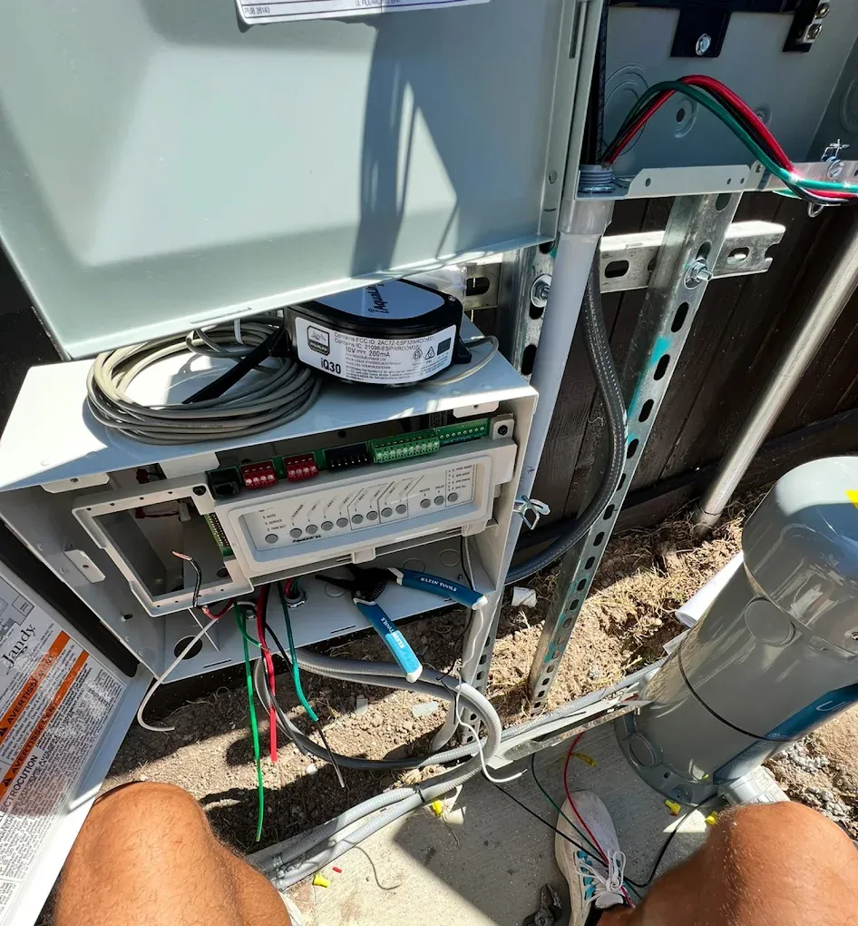 A person is sitting in front of a electrical box.