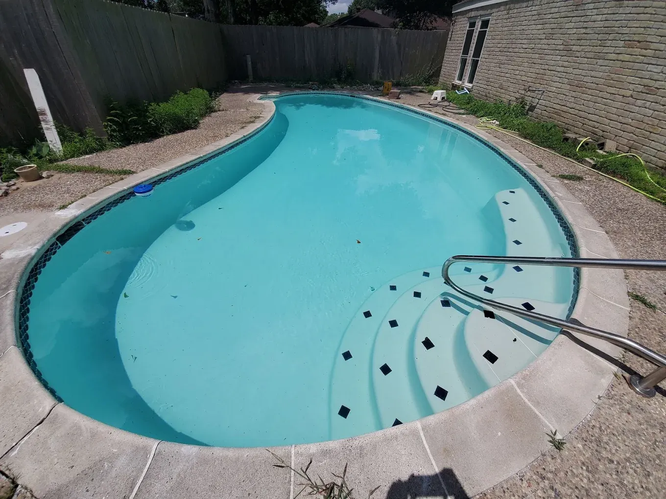A man is painting a swimming pool with a roller.