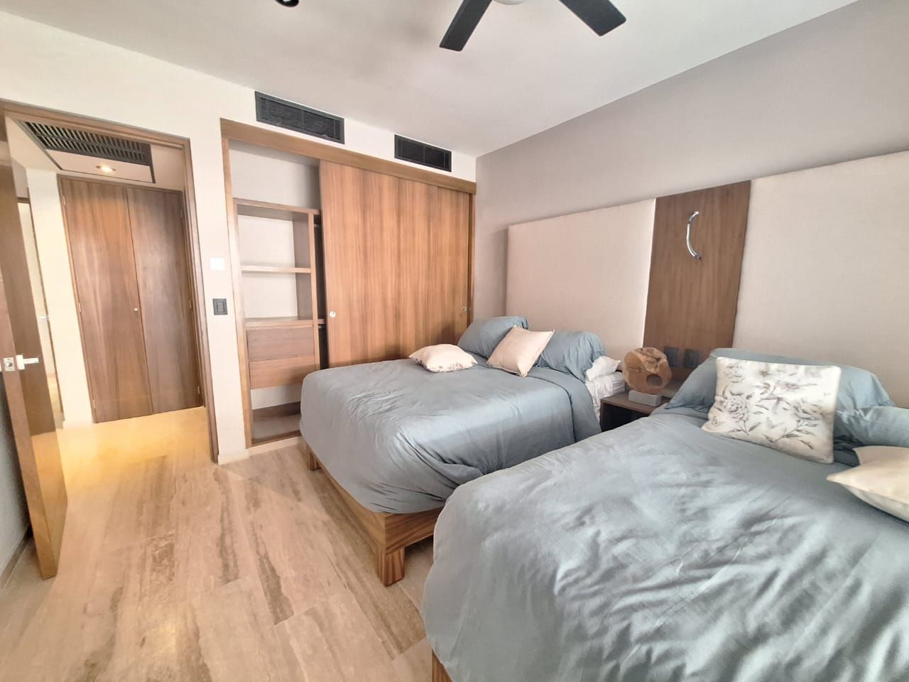 Un dormitorio con dos camas y ventilador de techo.