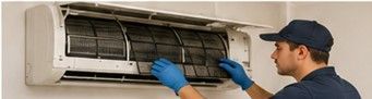 Técnico HVAC limpiando filtros de un minisplit, mantenimiento preventivo que recupera flujo de aire y evita consumo innecesario.