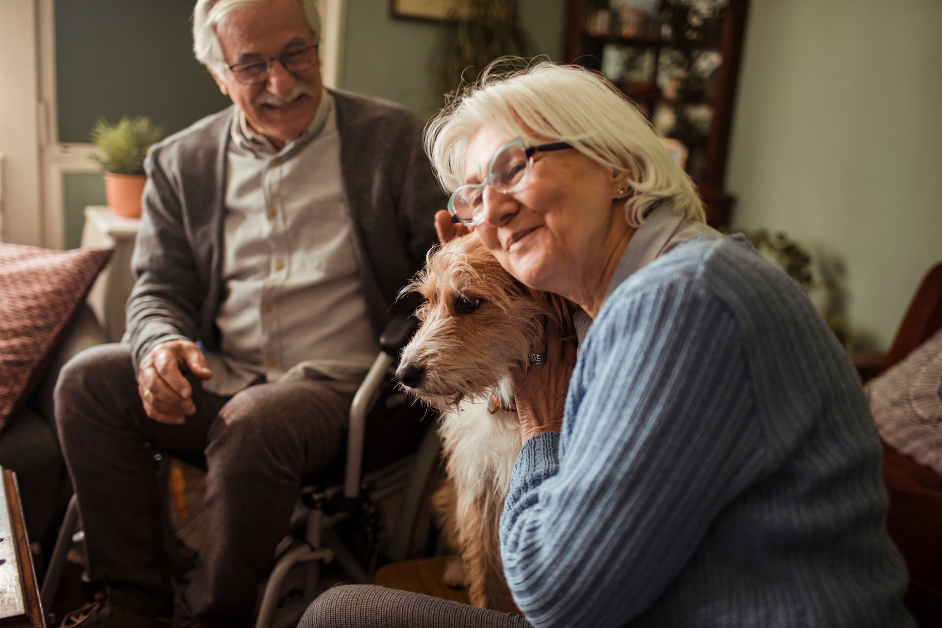 An elderly couple is sitting at a table talking to a woman.