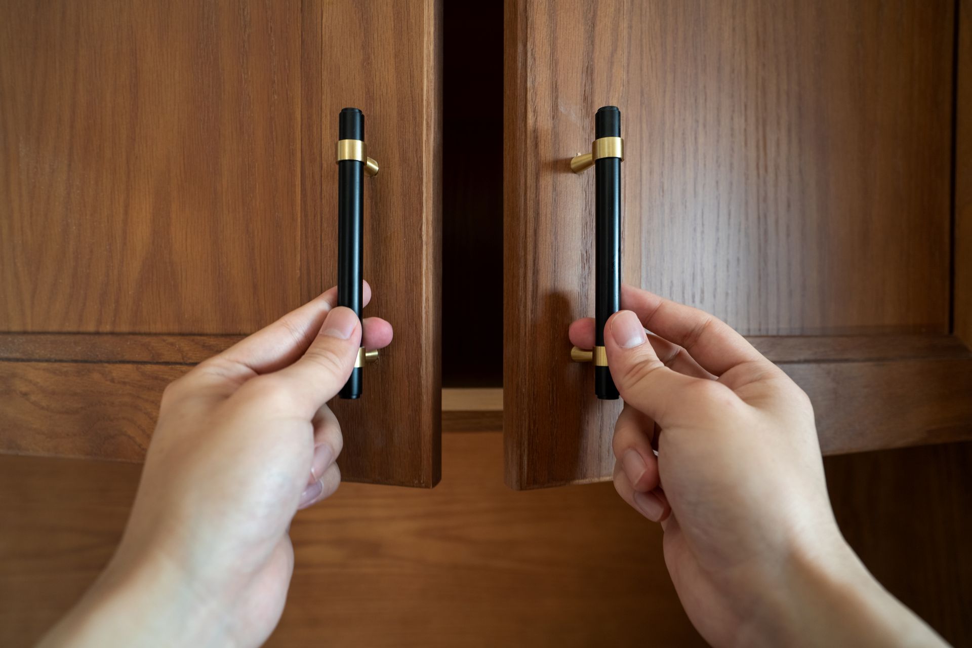 Hands open cabinet door