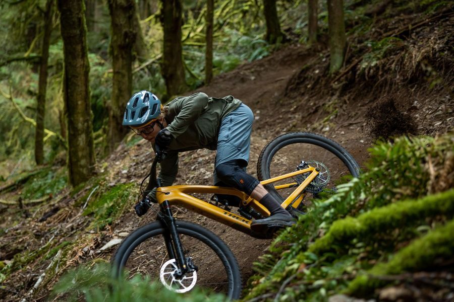 a man wearing a helmet is riding a bike on a trail