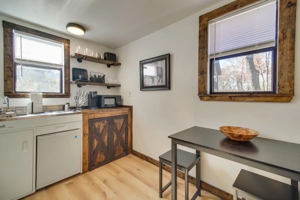 A kitchen with a table and chairs and a sink.