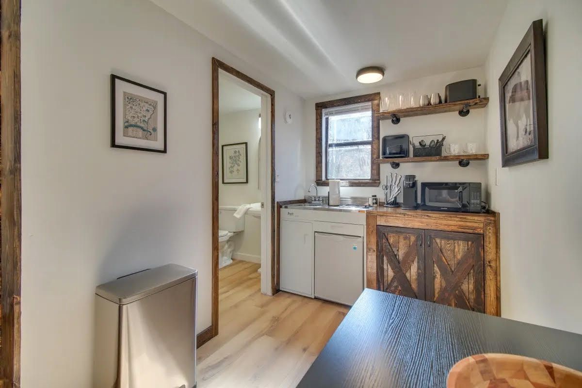 A kitchen with a table and a trash can in it