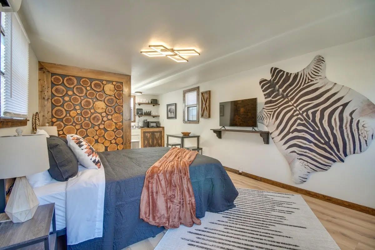 A bedroom with a bed and a zebra print on the wall.