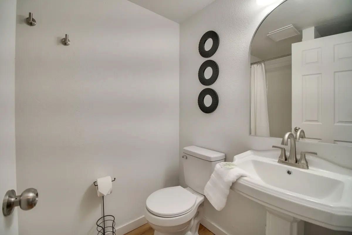 A bathroom with a toilet , sink and mirror