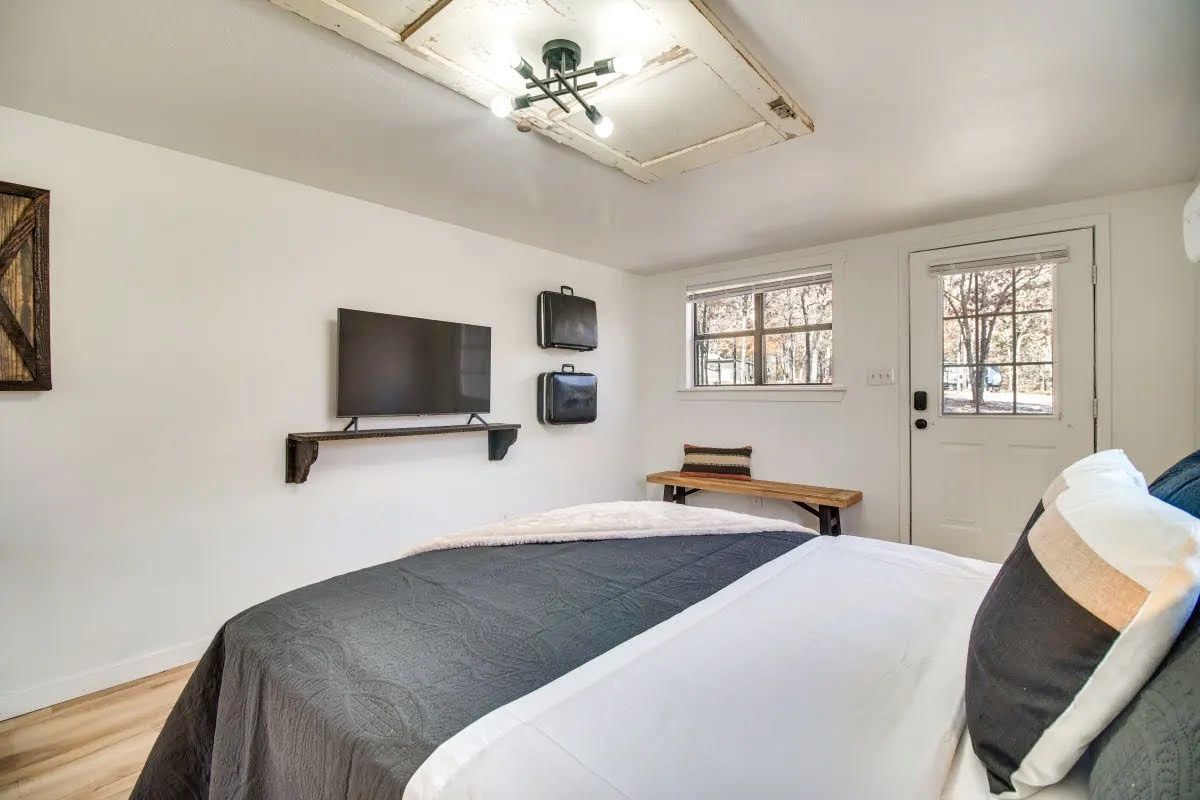 A bedroom with a bed , television and a ceiling fan.