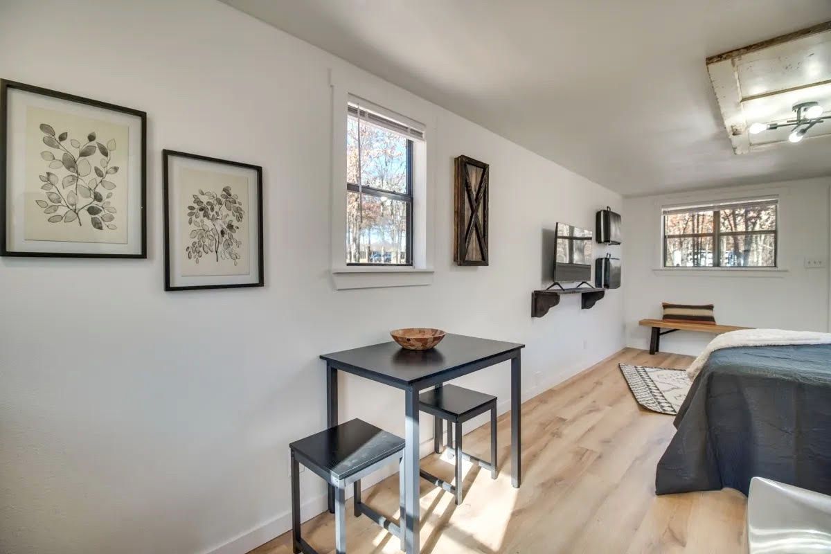 A bedroom with a table and chairs and a bed