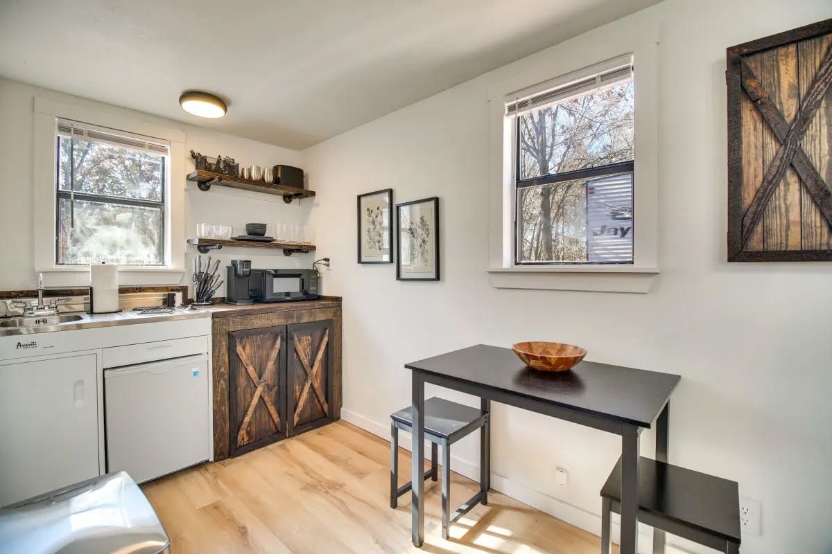 A kitchen with a table and chairs and a sink.