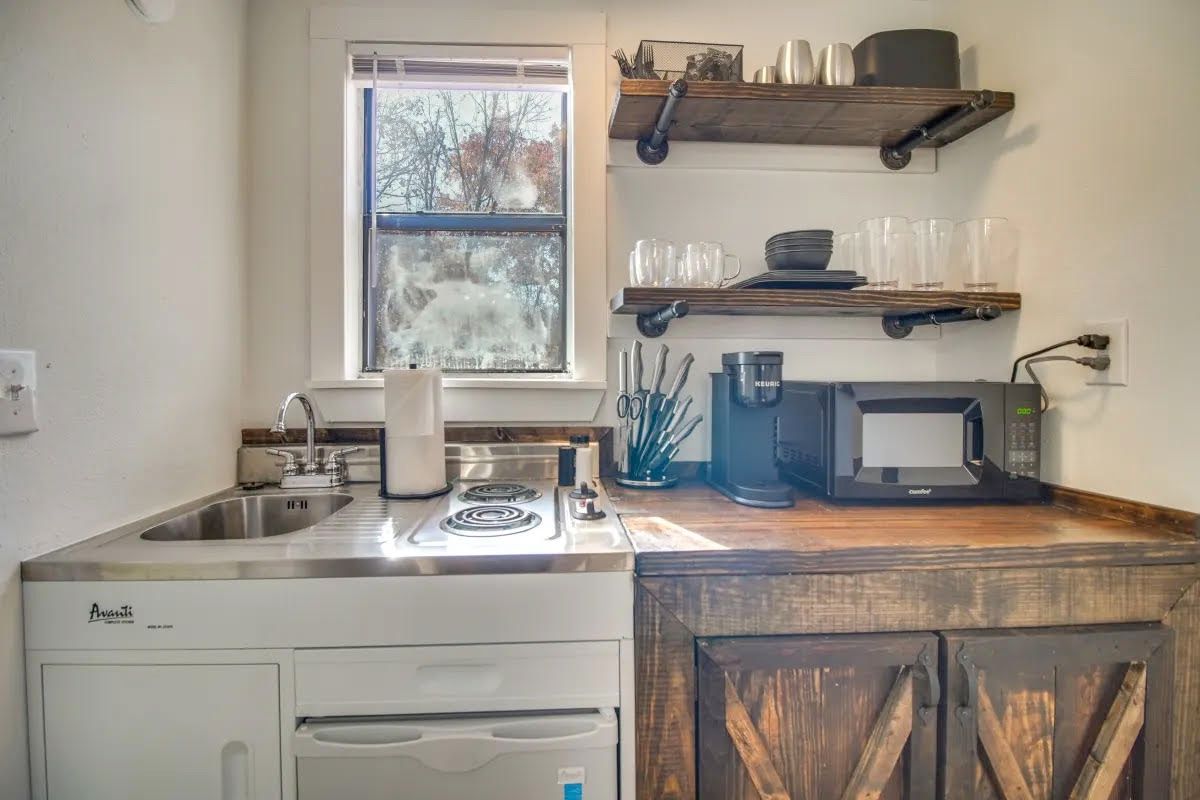 A small kitchen with a sink , stove , dishwasher , and microwave.
