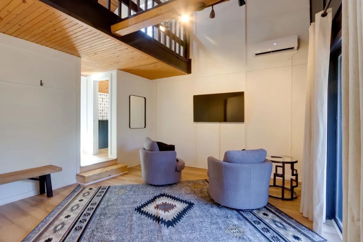 A living room with two chairs and a rug.