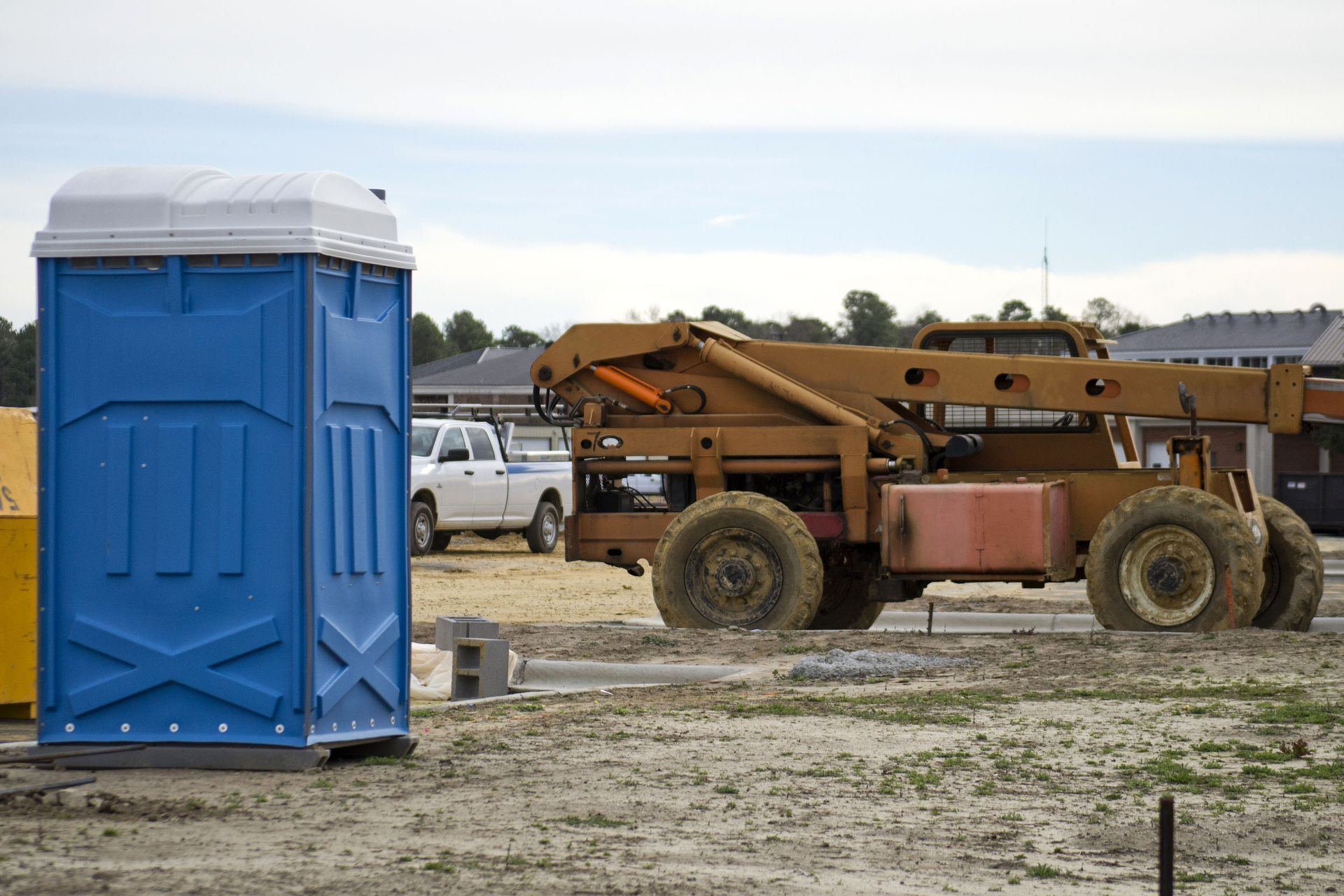 White utility truck beside flooded road with hoses; an orange lifebuoy ring in the water under cloudy skies