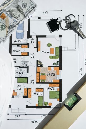 A top-down view shows keys, a one-hundred-dollar bill, and a small toy car placed on a printed architectural floor plan.