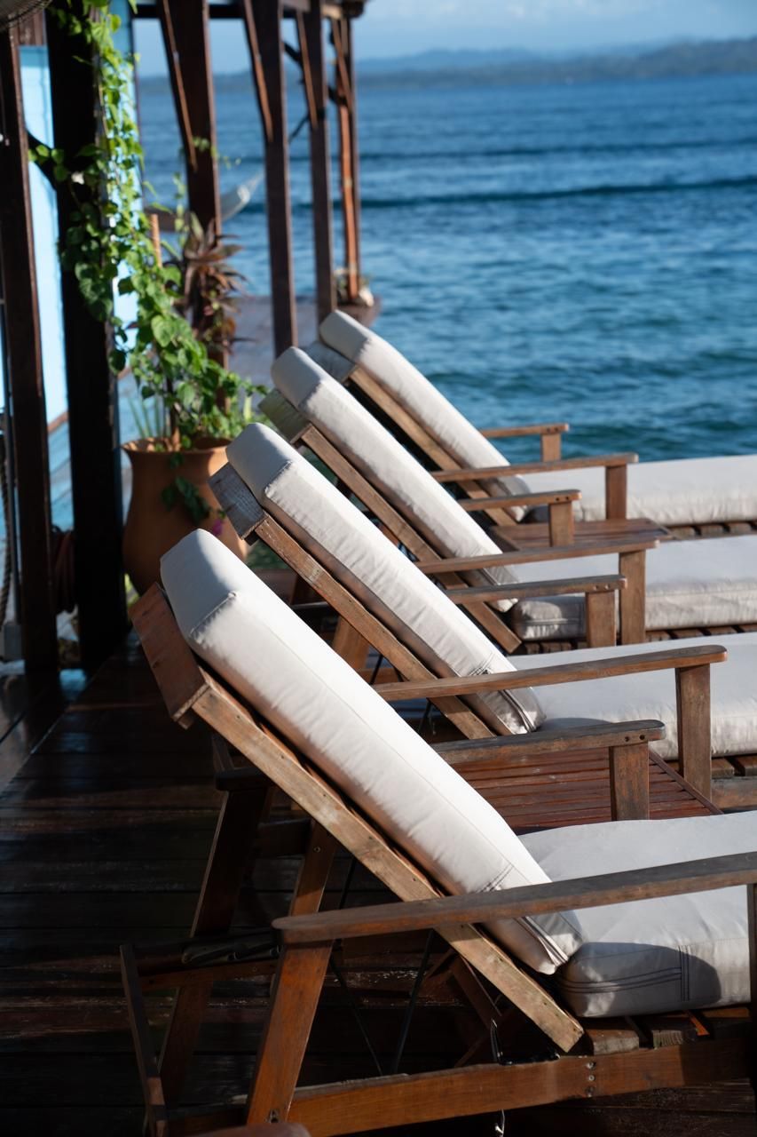 Wooden lounge chairs on a deck overlooking the blue ocean
