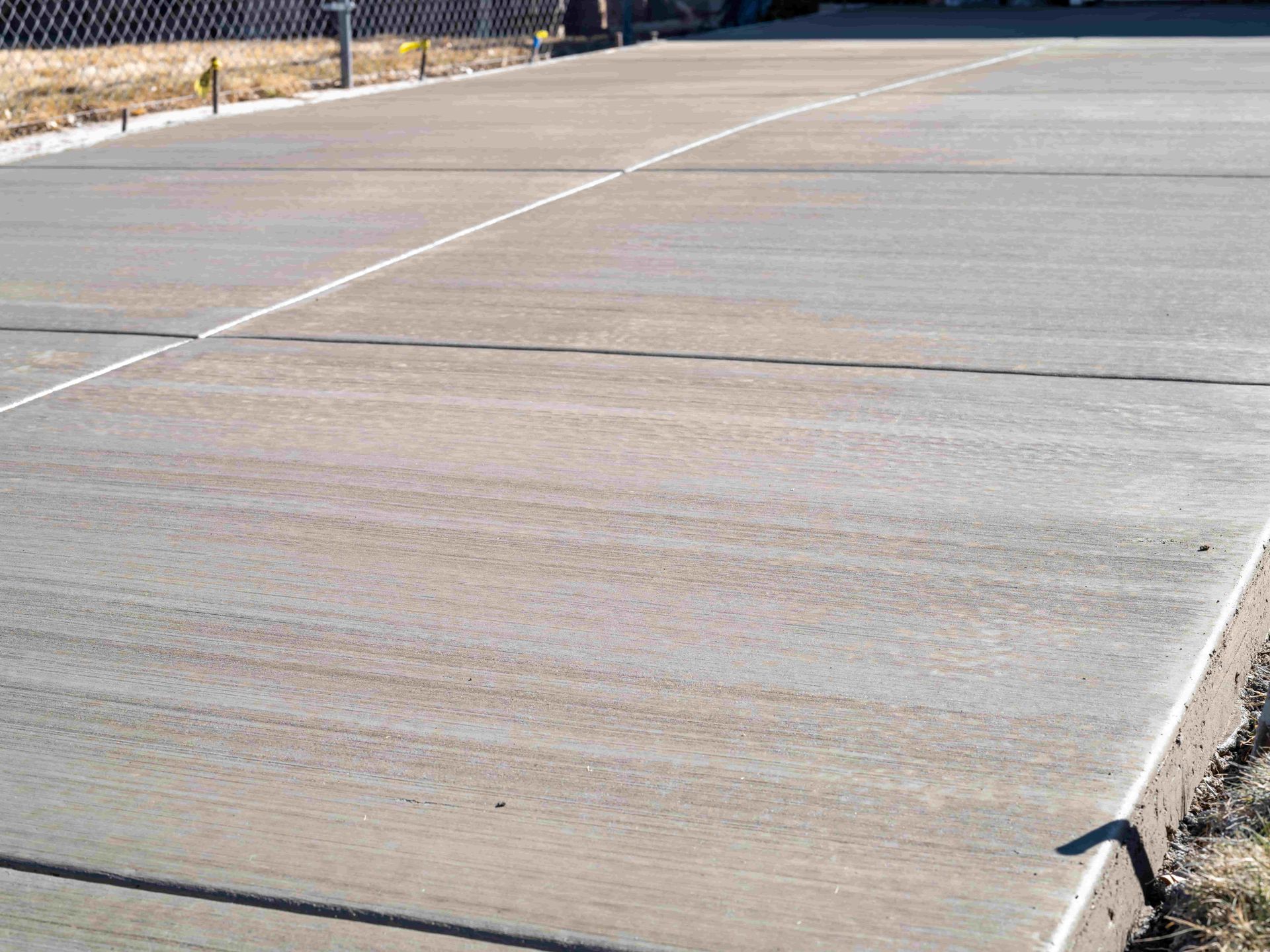 Concrete driveway with expansion joints and white painted edges.