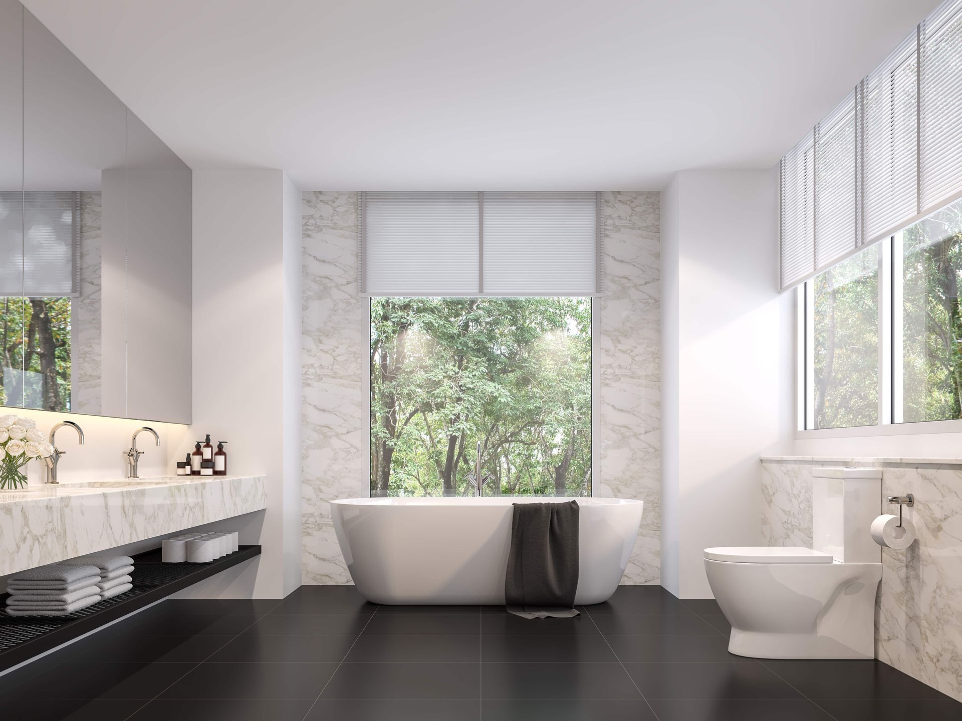 Modern bathroom with a white bathtub, toilet, and marble accents, overlooking a green outdoor view.