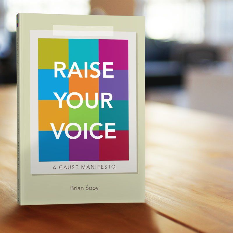 a book titled raise your voice sits on a wooden table