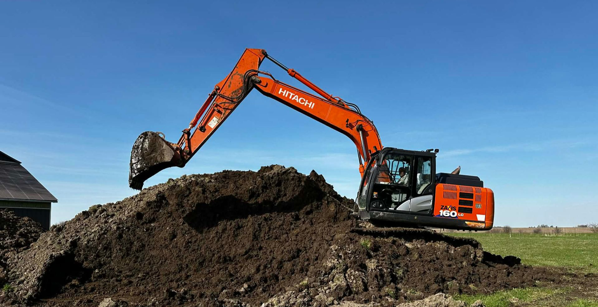 Hitachi excavator digging up dirt