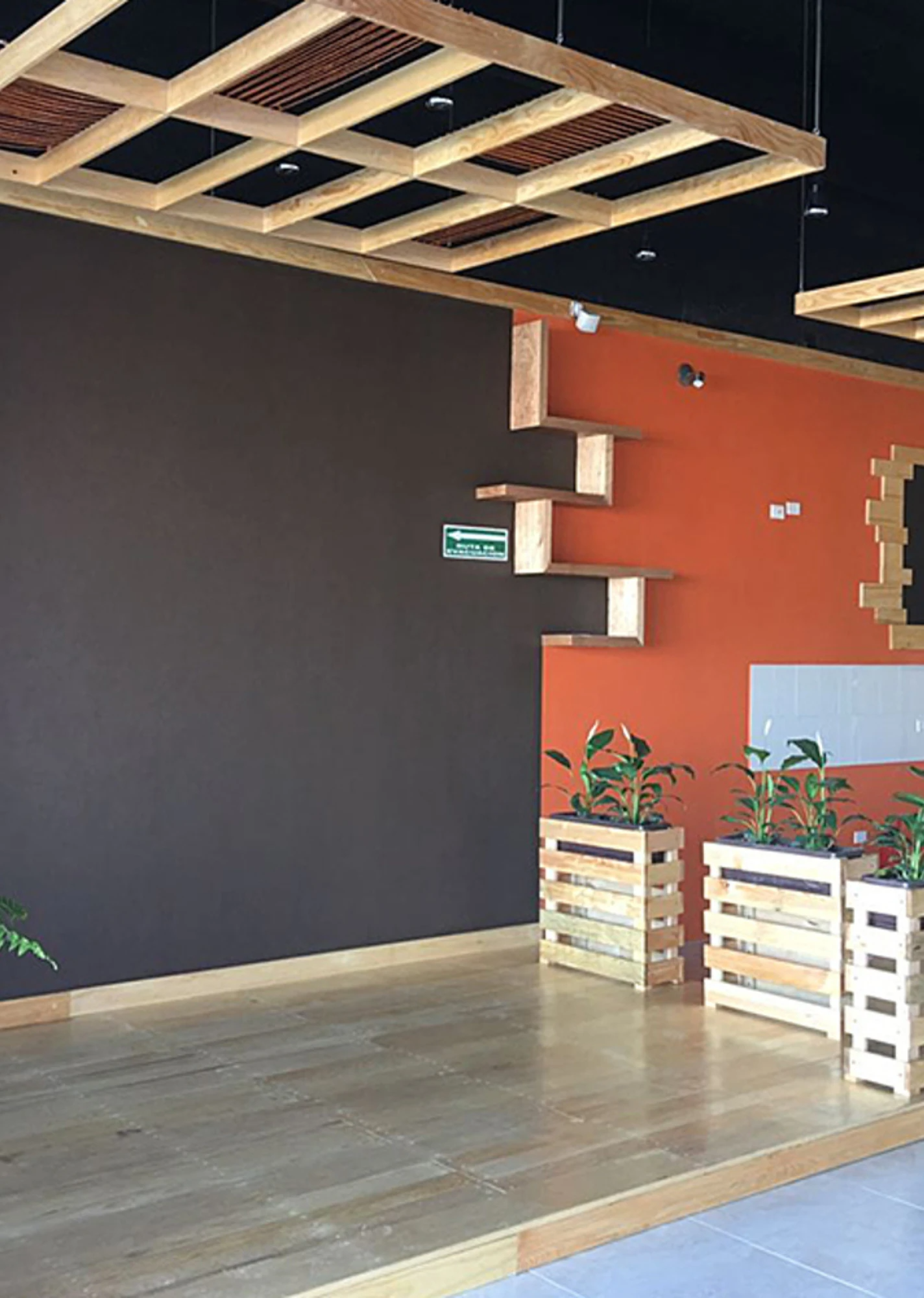 Interior moderno y vacío, con una pared oscura, una pared naranja