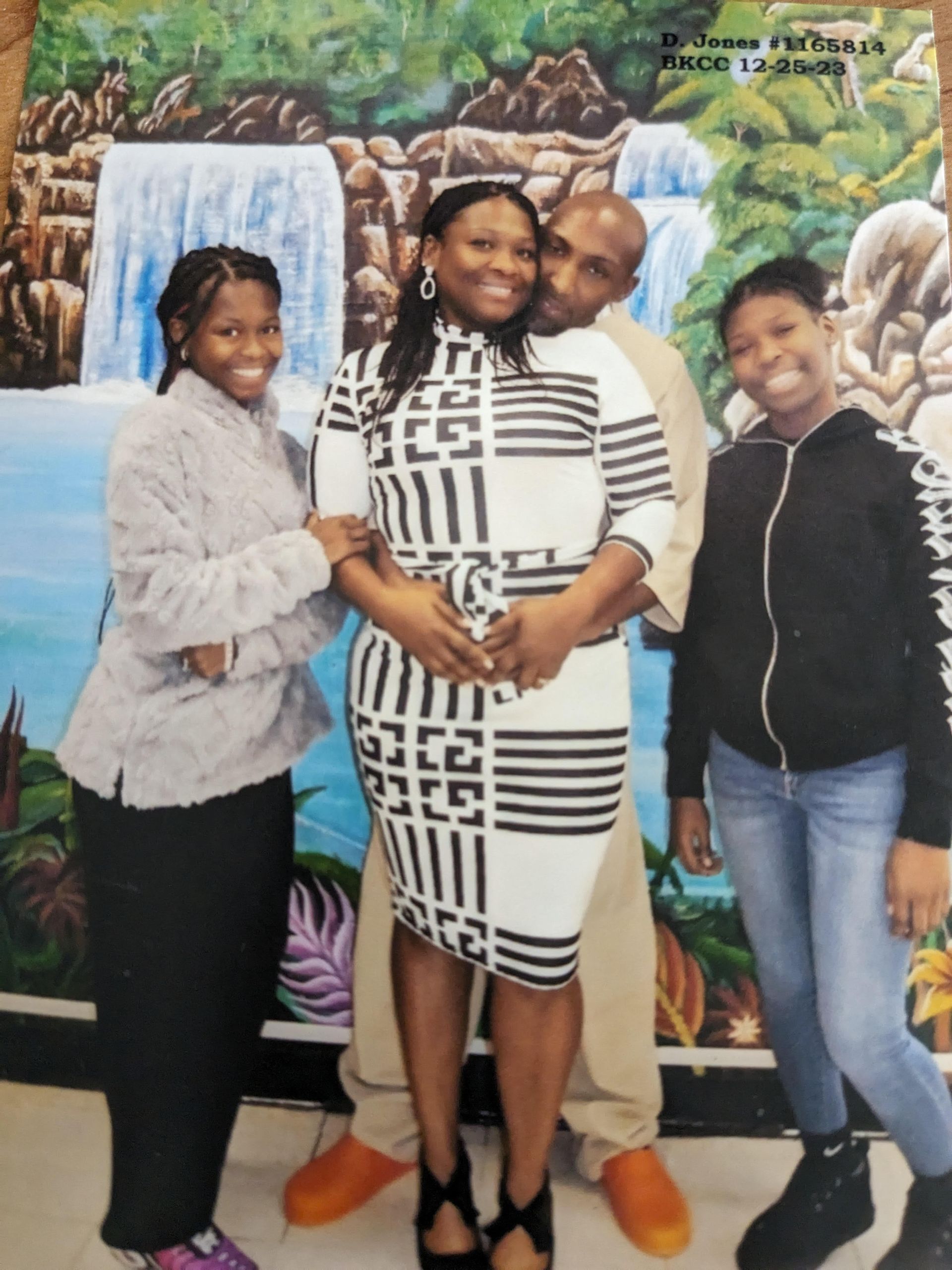A family posing for a picture in front of a waterfall