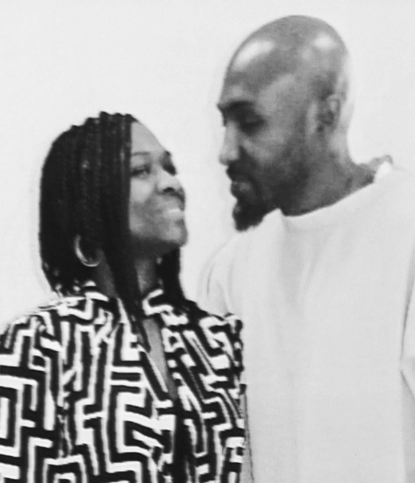 A man and a woman are looking at each other in a black and white photo.