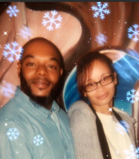 Man and woman smiling, snowflakes overlaid. Man wears blue shirt, woman wears glasses and gray sweater.