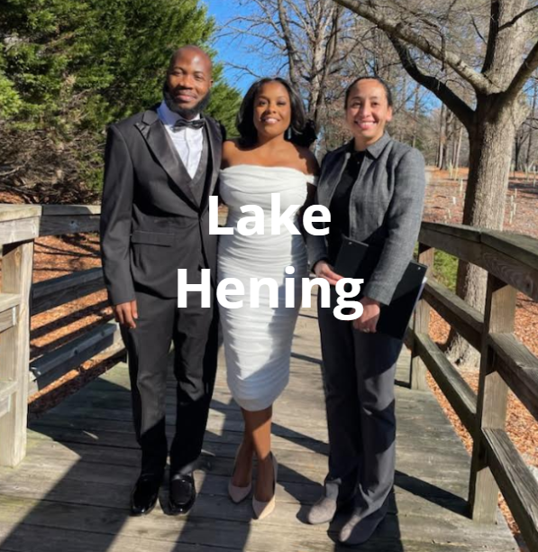 Couple and officiant at Lake Henning on a wooden bridge; couple smiling.