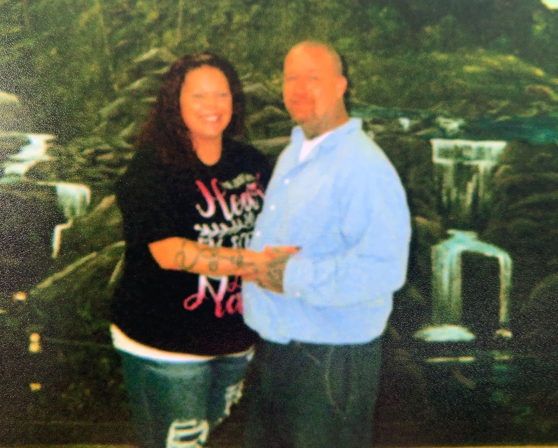 A man and a woman are posing for a picture and the woman is wearing a shirt that says new york