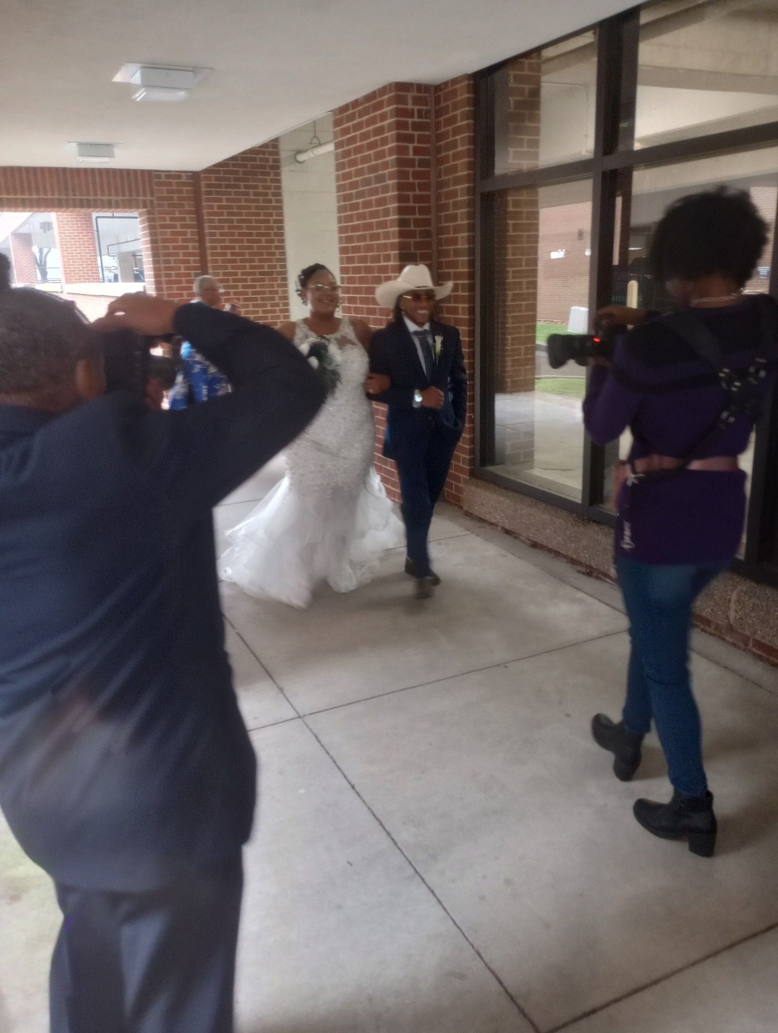 A man is taking a picture of a bride and groom
