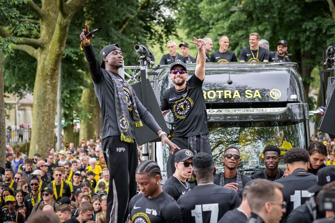 Un groupe de personnes debout devant un camion sur lequel est écrit Young Boys.