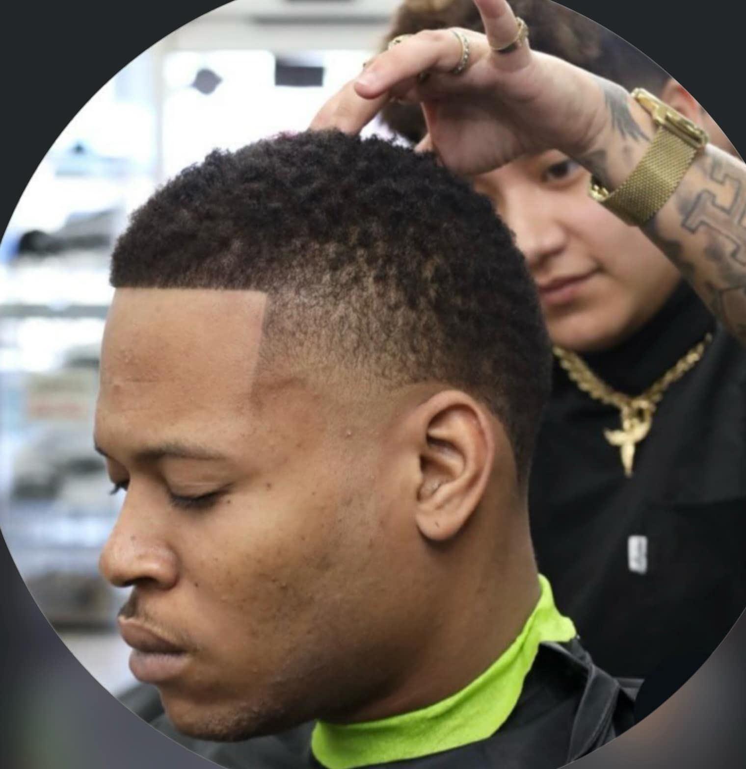 Man getting a short fade haircut while seated in a barber chair