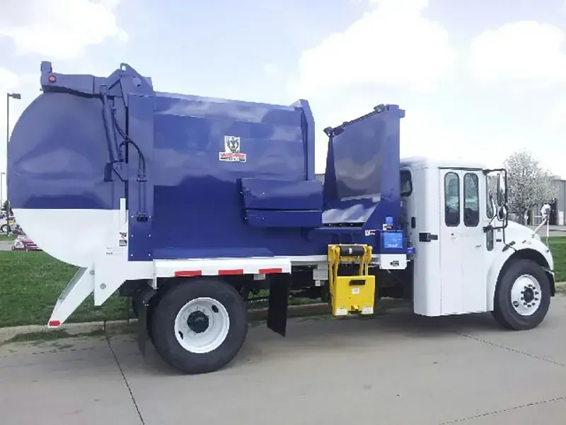Blue-and-white garbage truck parked on a street