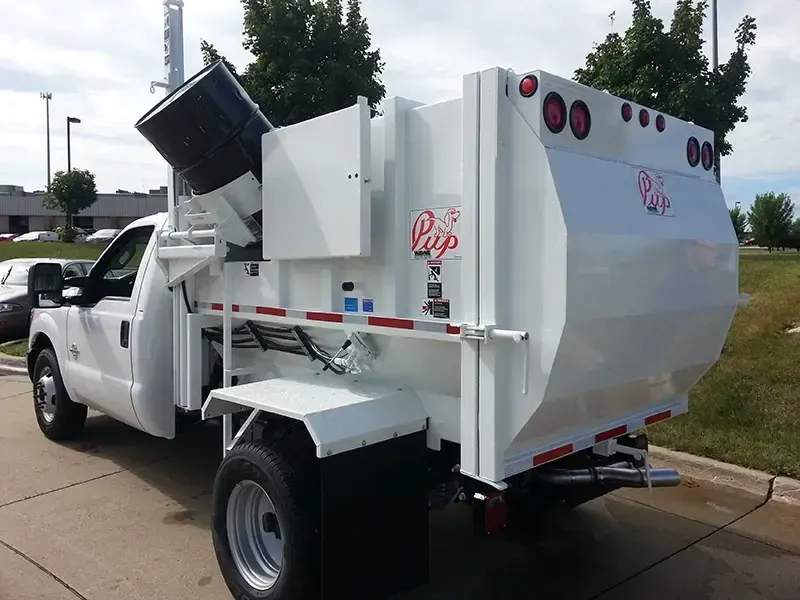 White utility truck with a lift bed and red lights parked outdoors on a road.