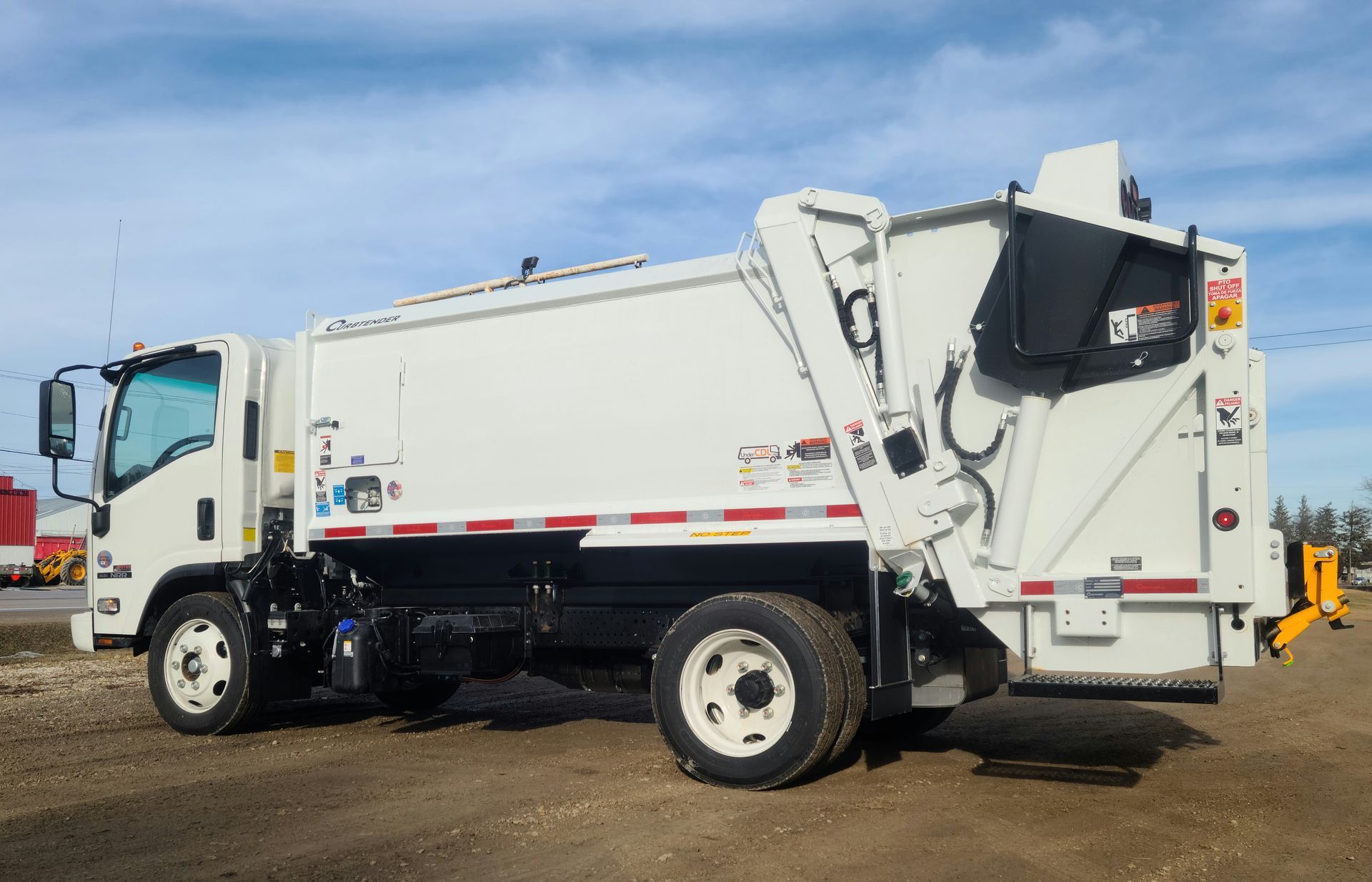 White garbage truck parked outdoors on a sunny day