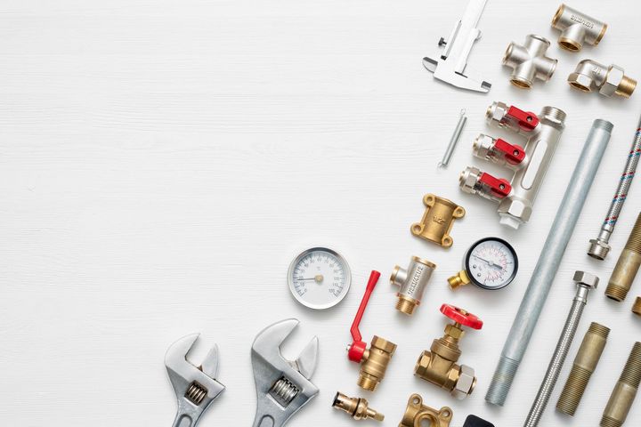 Plumbing parts are flat-laid on a white background, showcasing water system accessories. Plumbing parts are flat-laid on a white background, showcasing water system accessories.