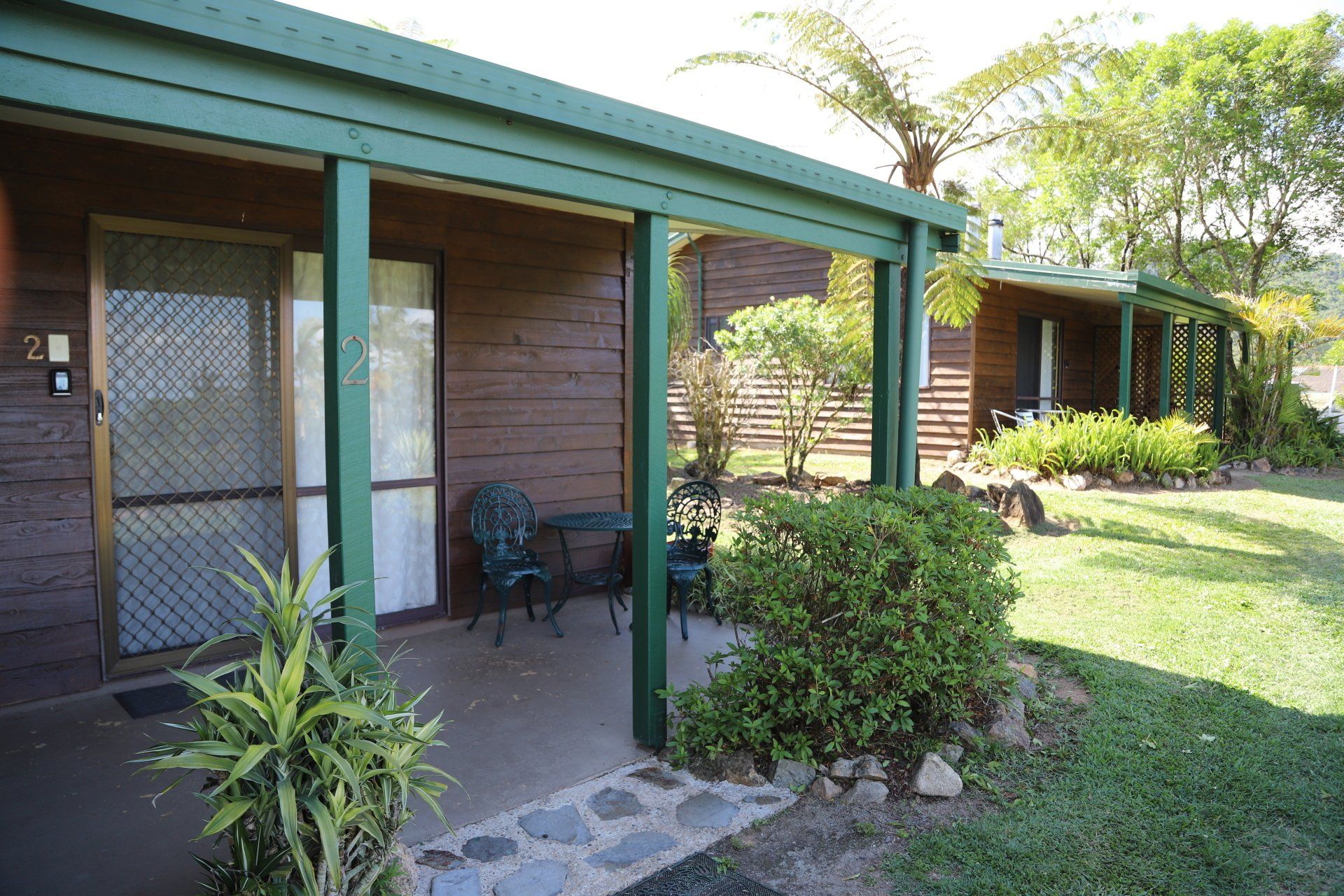 Wooden cabins with spectacular view of the pioneer valley  from the patio, set in a grassy yard.