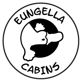 Logo for Eungella Cabins: Black and white circle with text around a black shape resembling a platypus.