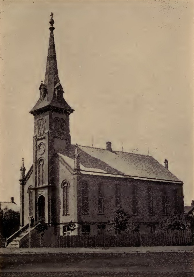 Old, tall brick church with steeple and clock tower.
