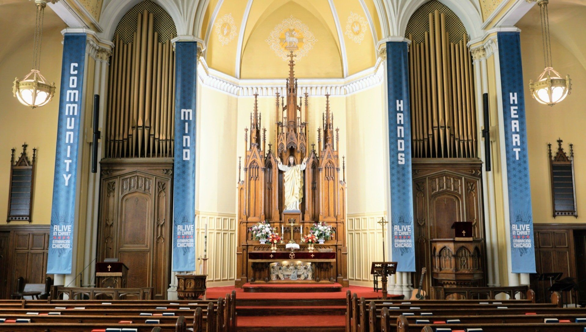 Interior of a church with an altar, organ, and banners that read 