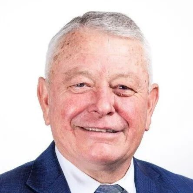 Smiling man in a blue suit jacket against a white background