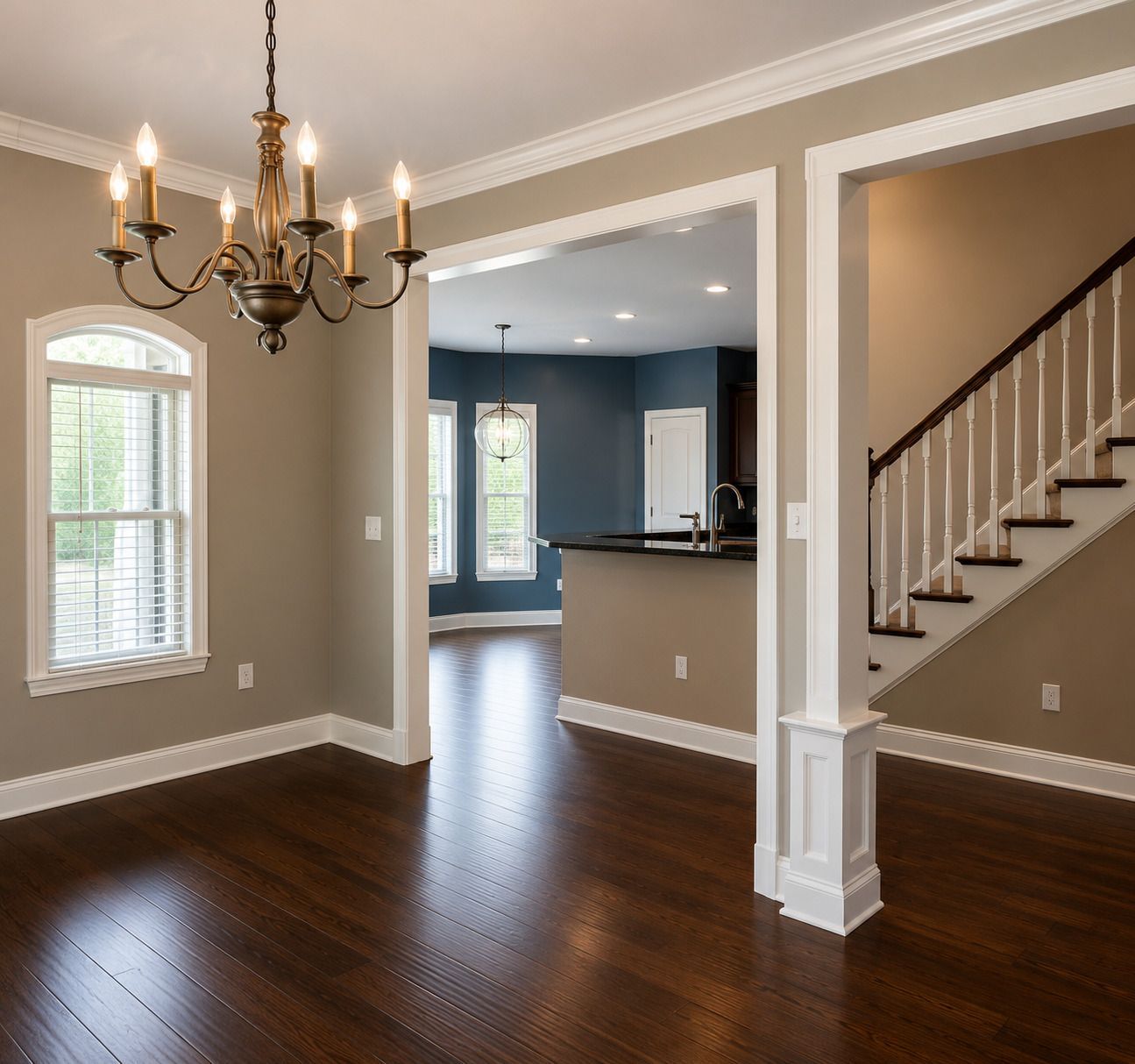 Empty dining room with chandelier, dark wood floors, and stairs leading to a kitchen area