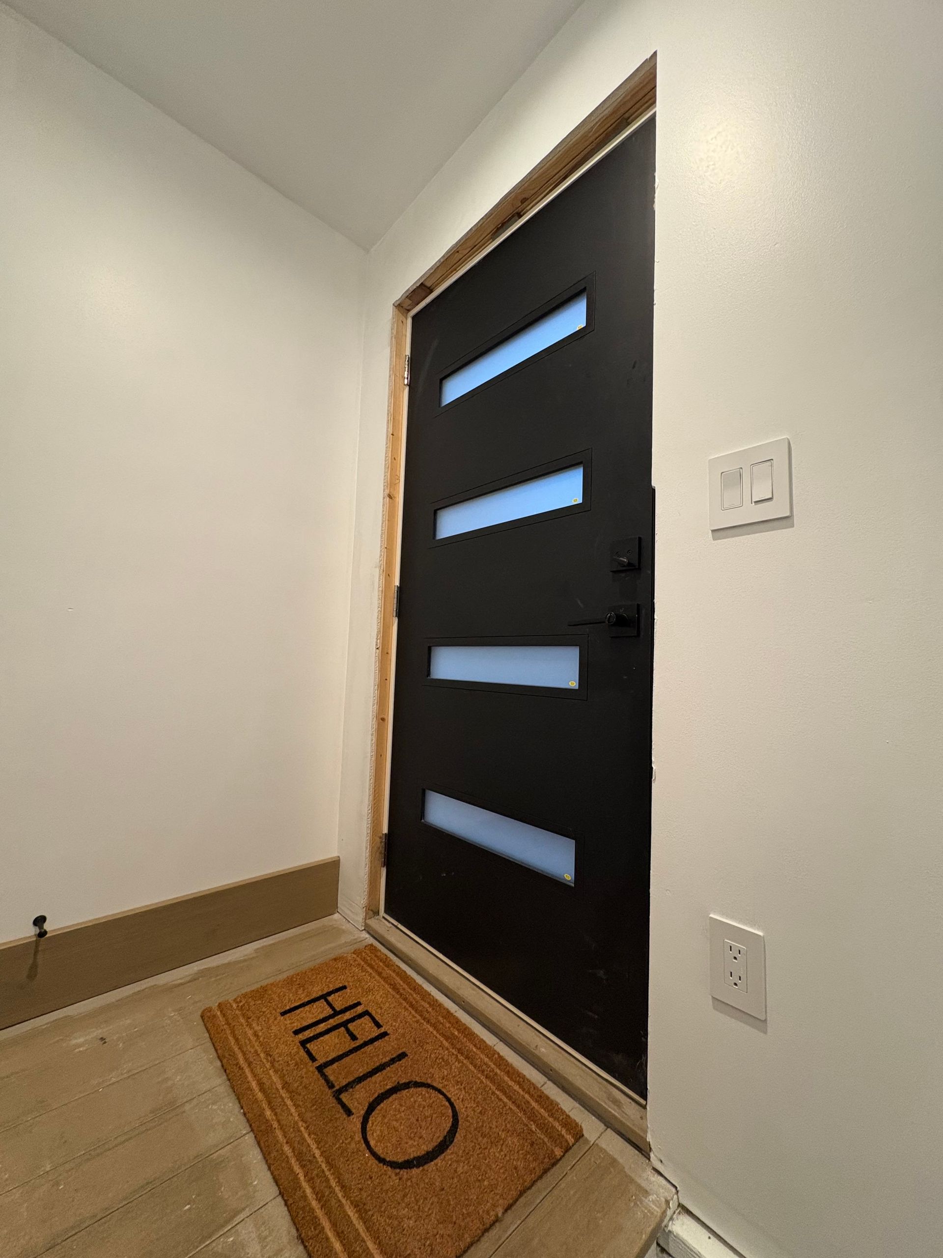 Black front door with four frosted glass panels, 