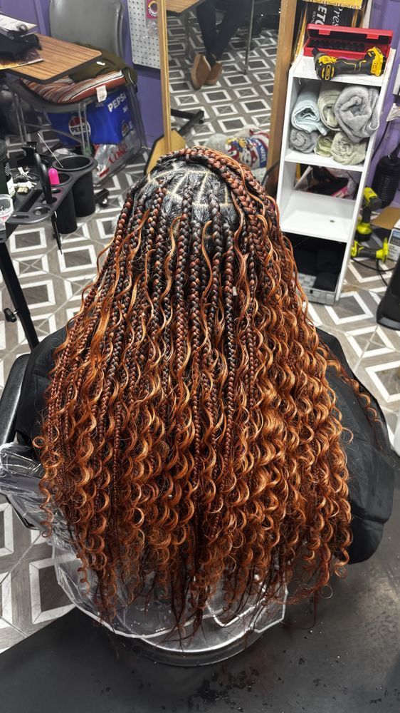 Braided hair with a curly, reddish-brown texture cascading down. Braids are at the roots.