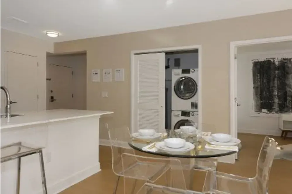 A kitchen with a table and chairs and a washer and dryer