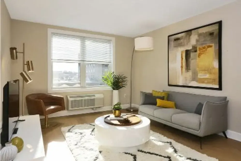 A living room with a couch , chair , coffee table and television.